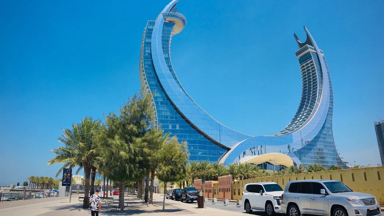 The crescent-shaped Katara Towers skyscraper in Doha against a clear blue sky.