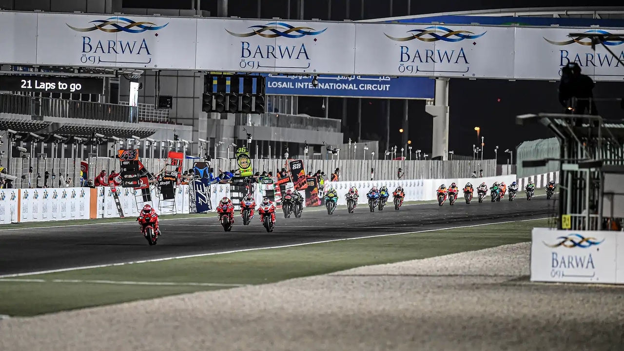 MotoGP field racing under floodlights at Lusail International Circuit 