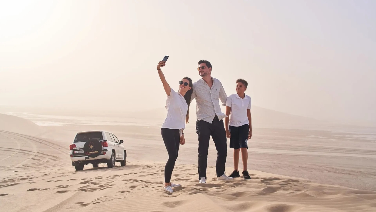 Family taking a selfie during a desert safari in Qatar.