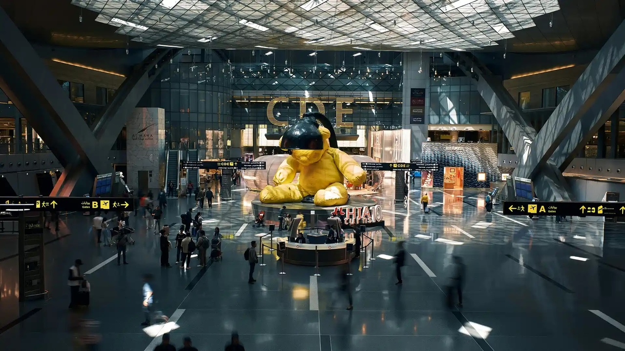 The famous giant yellow Lamp Bear statue inside Hamad International Airport terminal.

