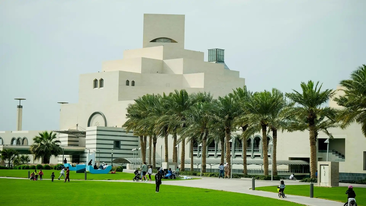 Families on the lawns of MIA Park with the museum and palm trees behind